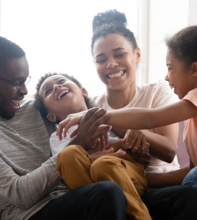 family sit together laughing and playing together as part of emw law firms individuals and families page for solicitors and legal services